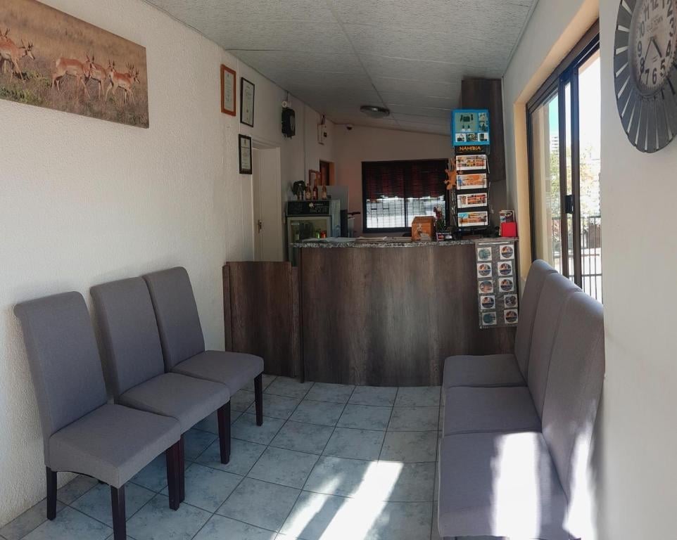Reception and waiting area with grey upholstered chairs and wooden desk, antelope artwork on wall